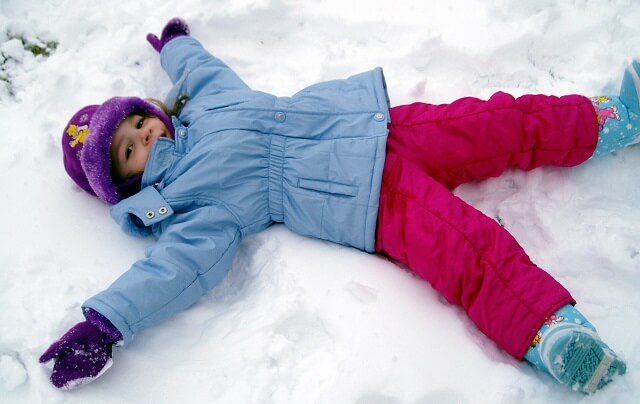 nina haciendo un angel de nieve