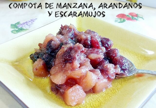 compota de manzana arandanos y escaramujos en un plato de postre con una cucharilla