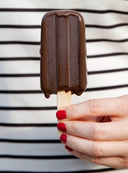 chica sostiene en su mano un helado de chocolate