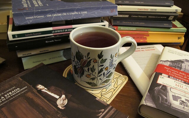 taza con una infusion entre muchos libros