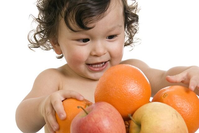 bebe junto a frutas