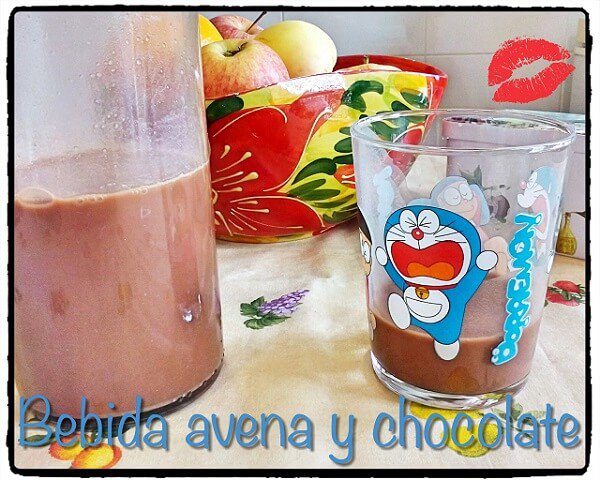 una vaso y botella de cristal con bebida de avena y chocolate