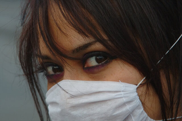 chica con mascarilla contra la gripe