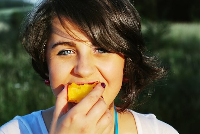 chica comiendo un melocoton