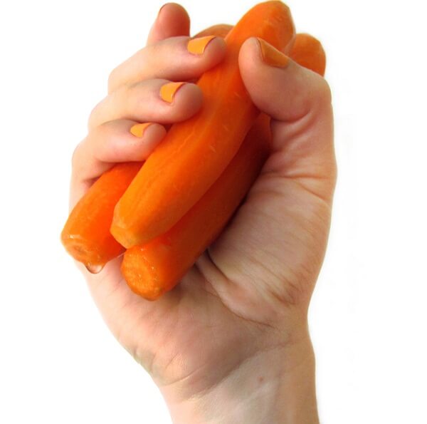 mano sujetando zanahorias peladas