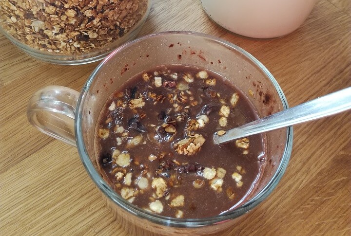 una taza con granola y leche de avena.