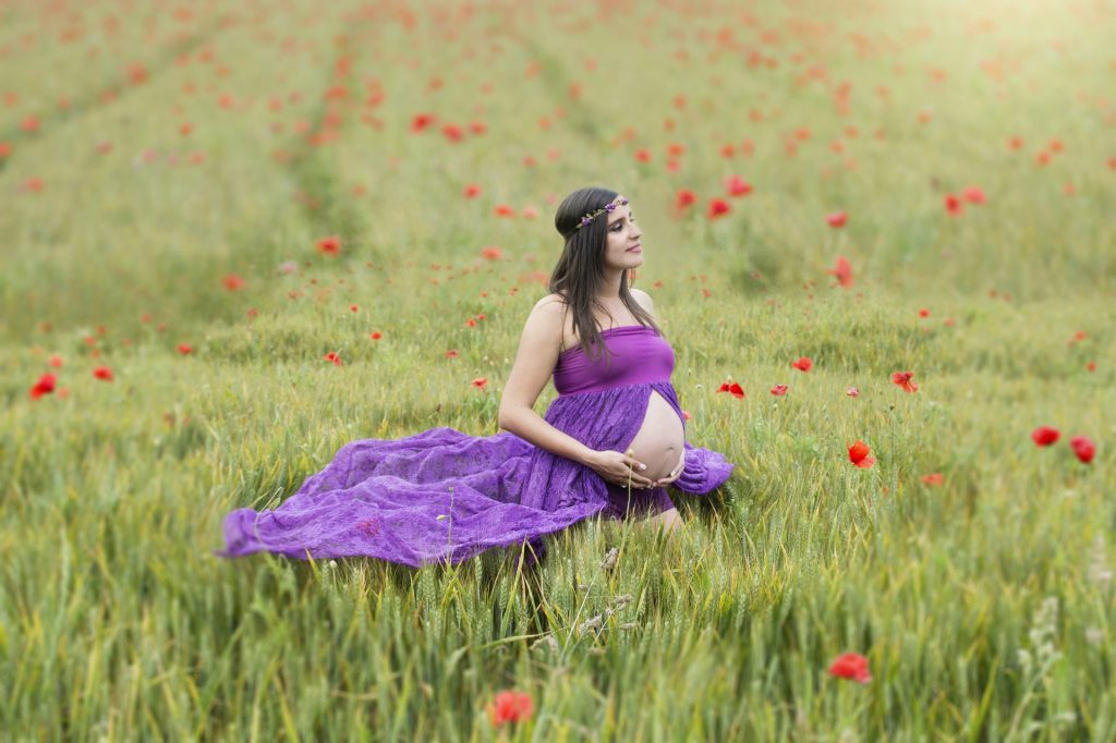 mujer embarazada en medio de un campo de amapolas