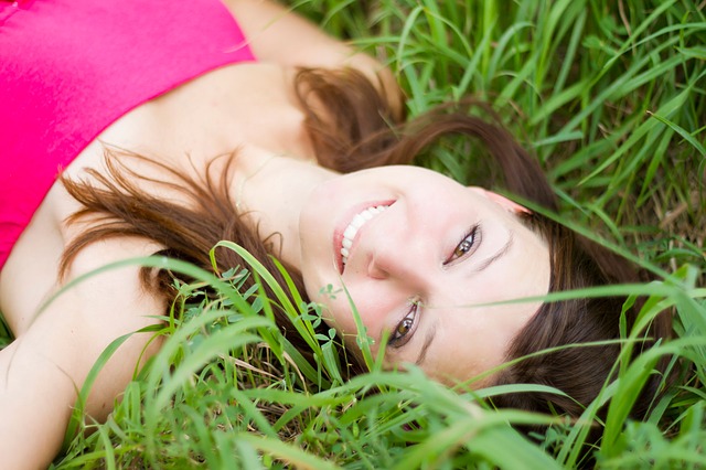 chica tumbada en el cesped con cara sonriente