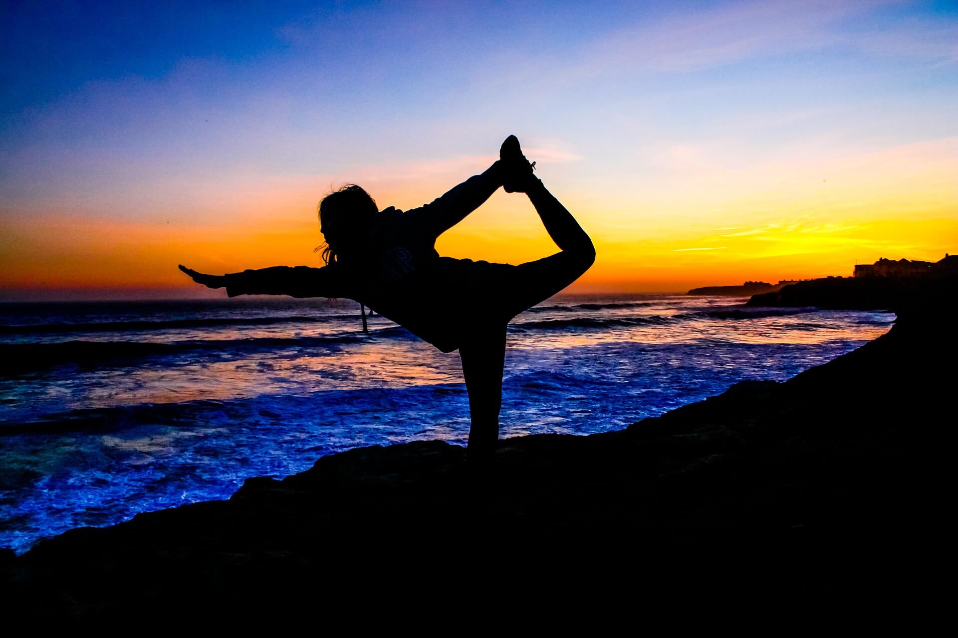 chica haciendo yoga en la playa